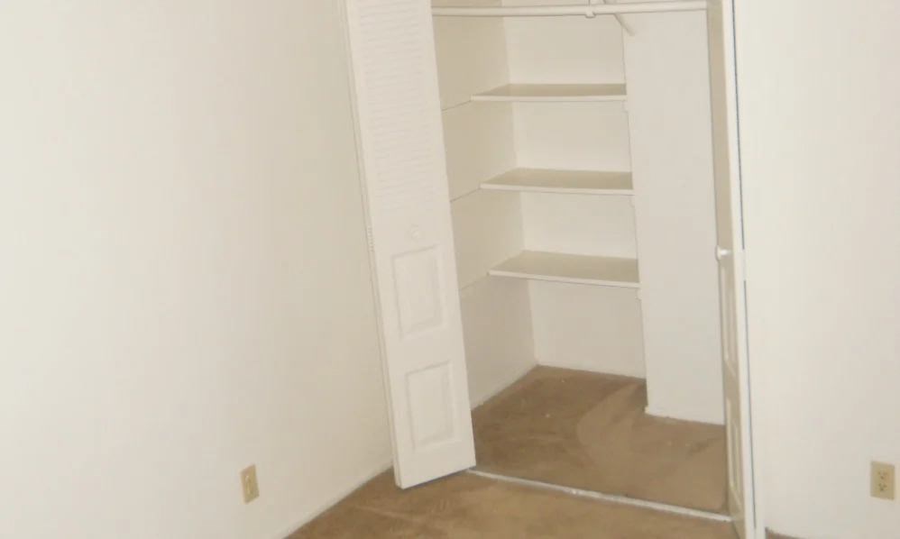an empty closet in a room with a white door