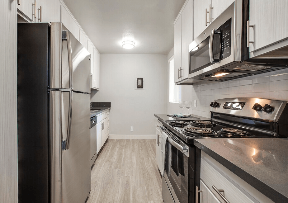 A modern kitchen with stainless steel appliances and white cabinets.