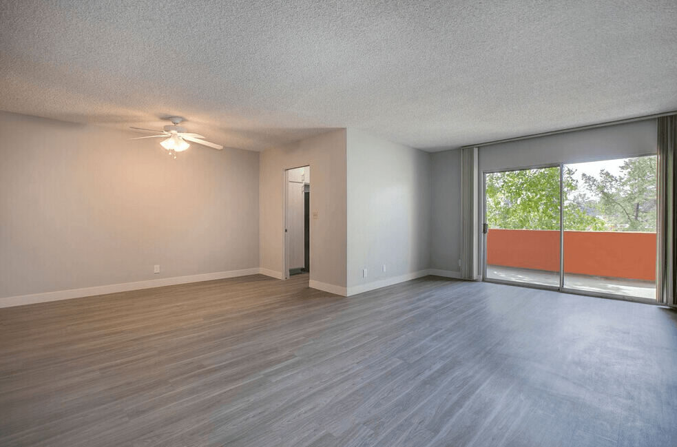 A room with a sliding glass door leading to a balcony.