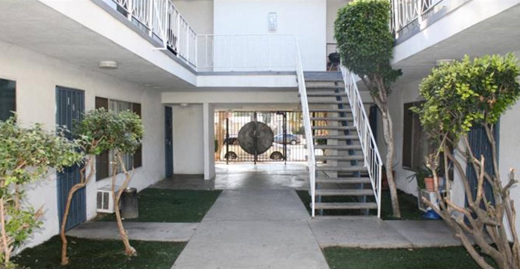 A white building with a staircase leading to the second floor.