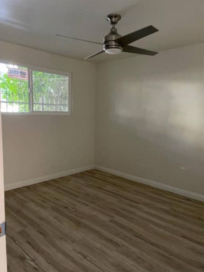 an empty room with a ceiling fan and a window