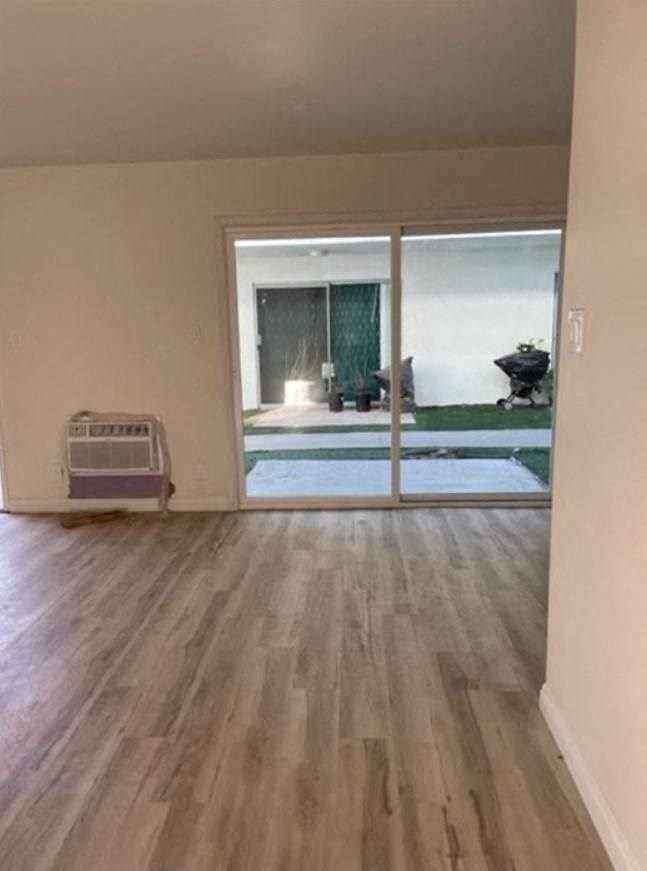 an empty living room with a hard wood floor and sliding glass doors