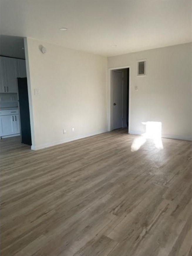 an empty living room with white walls and wooden floors