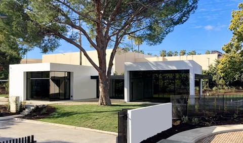A modern house with a white exterior and a black fence.