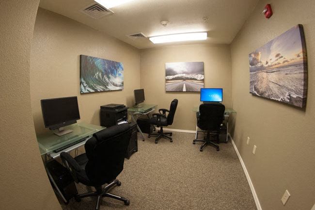 a room with three desks and three computers
