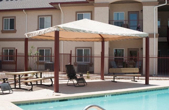 a large umbrella sitting next to a swimming pool