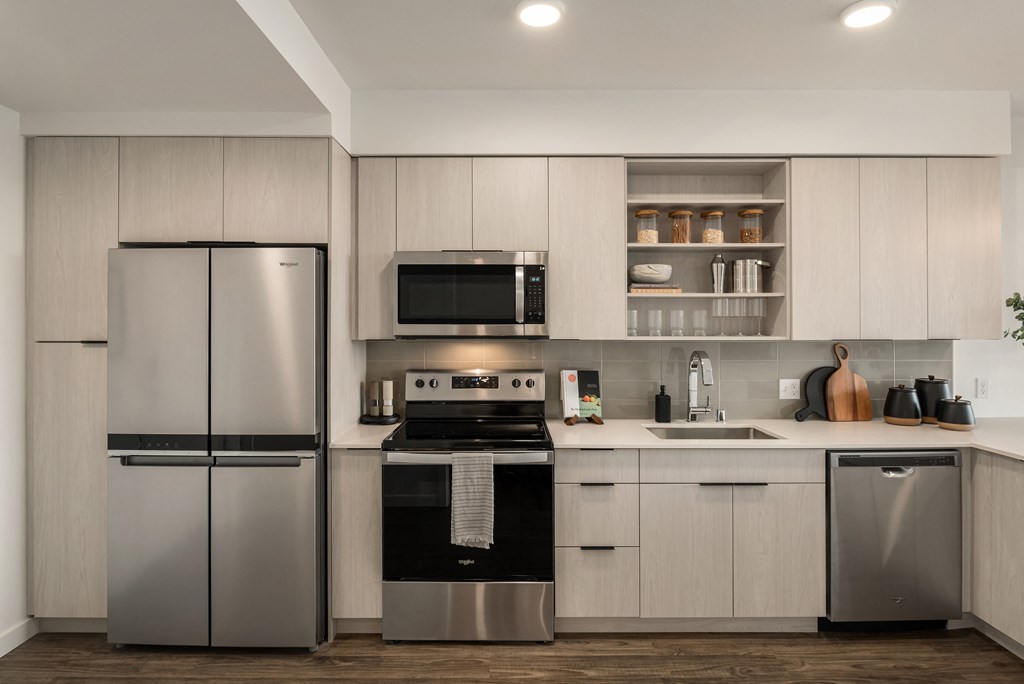 a kitchen with white cabinets and stainless steel appliances