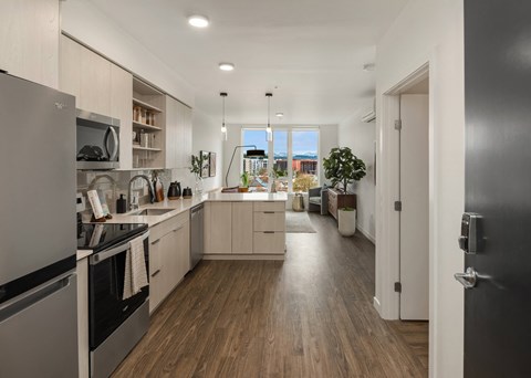 a kitchen and living room with hardwood floors and a large window