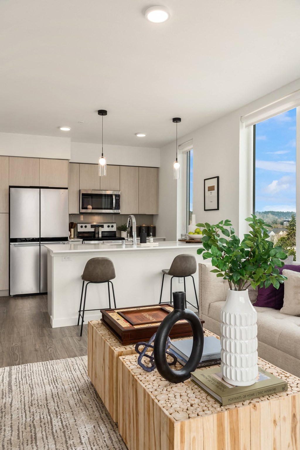 a living room with a kitchen in the background