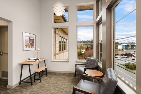 a living room with chairs and a table and a window