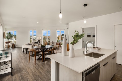 a kitchen and living room with a dining room in the background