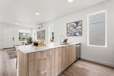 A kitchen with a white countertop and wooden cabinets.