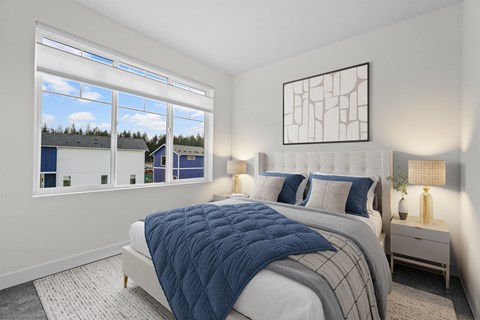 A bedroom with a large bed and a view of the outside through the window.