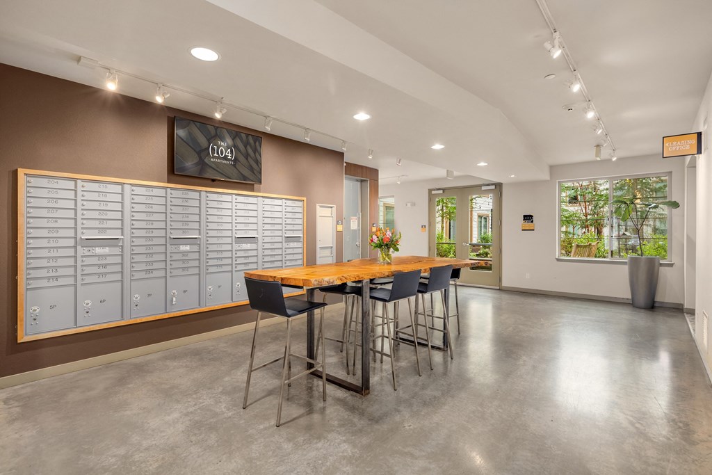 a communal area with a table and chairs in front of lockers