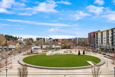 a park with a grassy area and buildings in the background