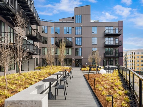 a patio with tables and chairs in front of a building