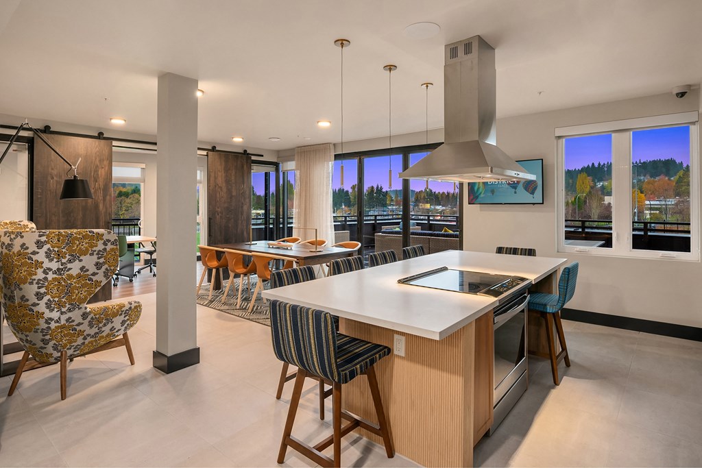 a large kitchen with a large island and a dining area with chairs and a bar