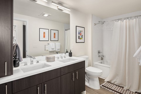 a bathroom with two sinks and a toilet and a shower