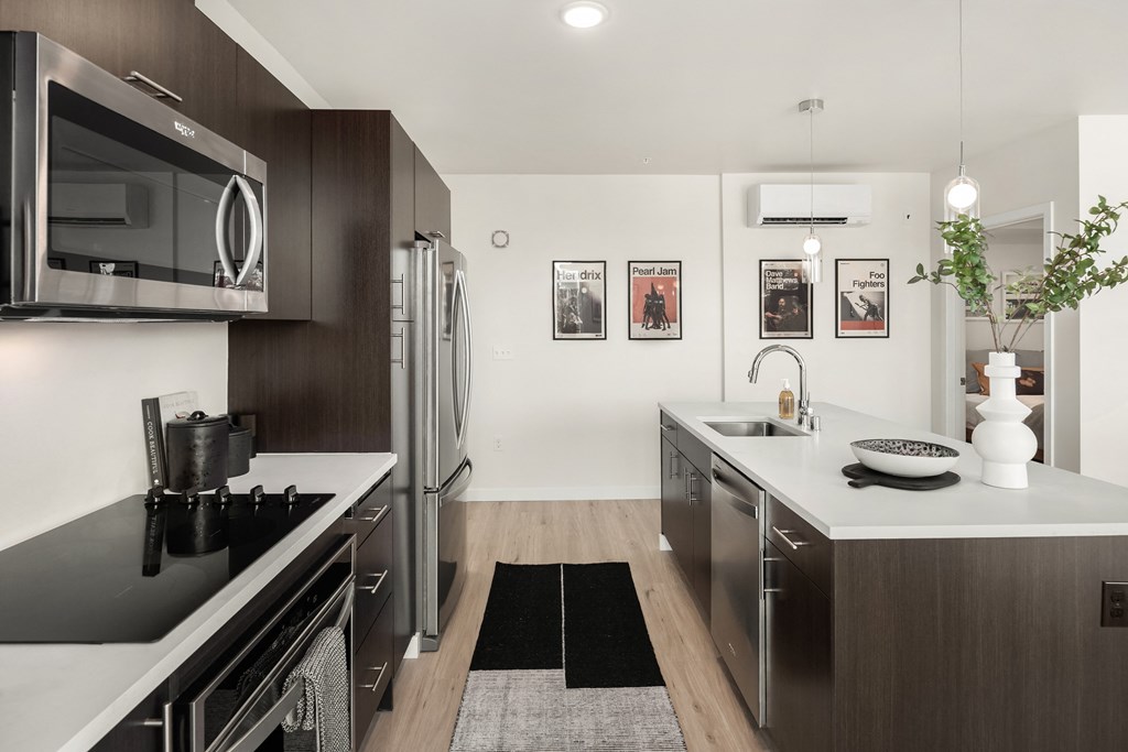 a modern kitchen with stainless steel appliances and white counter tops