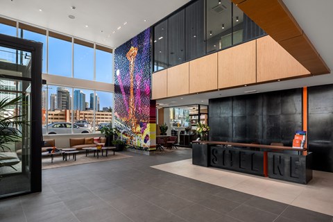 the lobby of a hotel with a colorful wall in the middle