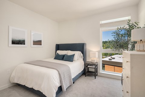 a bedroom with a bed and a large window