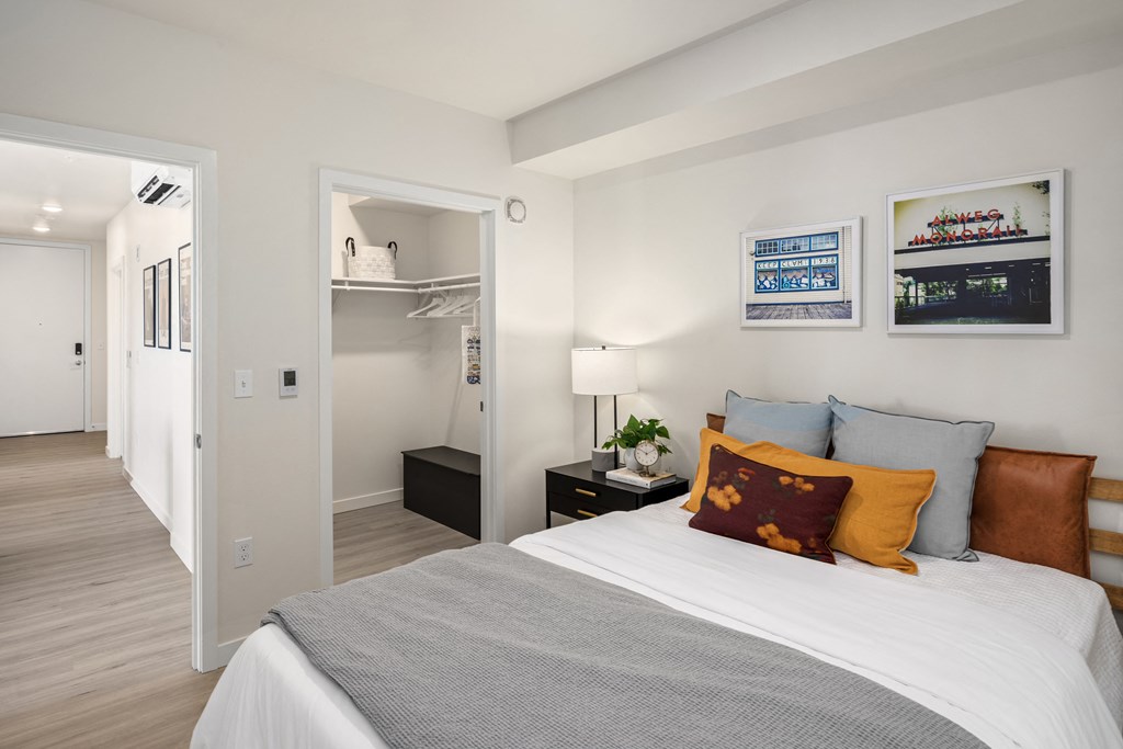 a bedroom with a bed and a closet      and a hallway