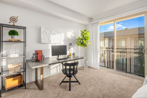 a home office with a desk and a window