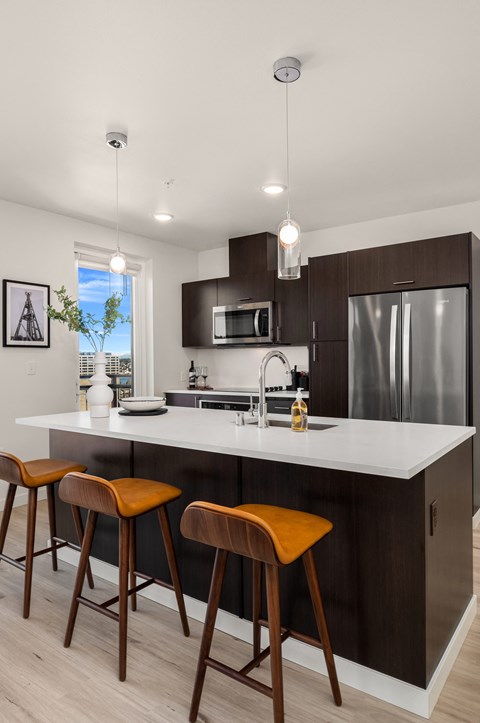 a kitchen with a large island with three wooden stools