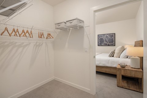a bedroom with a closet and a bed in a room with a mirrored door