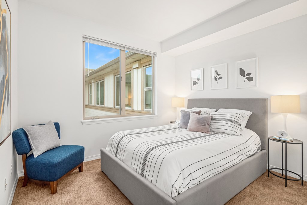 a bedroom with a bed and a large window