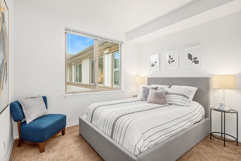 a bedroom with a bed and a large window