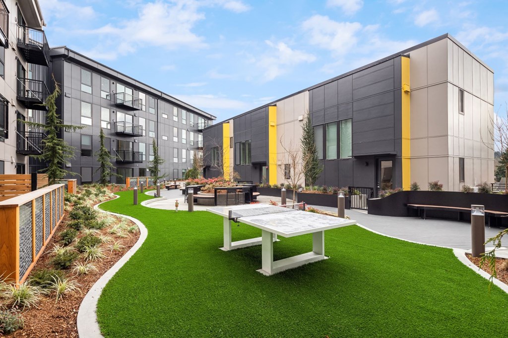 a courtyard with a picnic table in front of some buildings