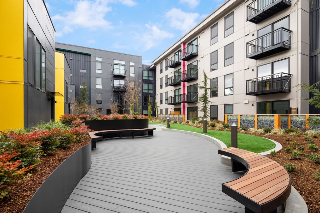 a path with benches in front of some buildings