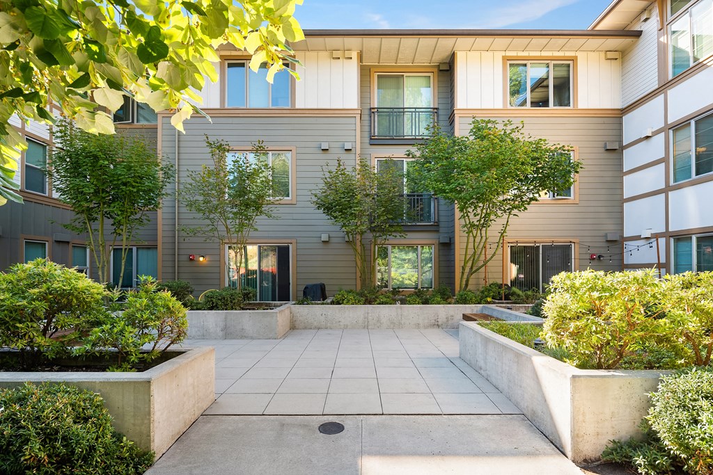 the courtyard of an apartment building with trees and plants