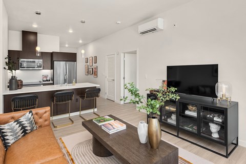 a living room with a fireplace and a kitchen with a table and chairs