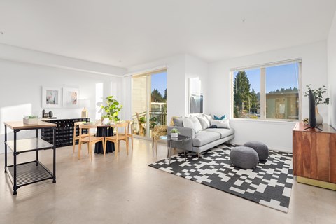 a living room with a couch and a rug and a dining room table with a