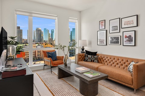 a living room with a couch and a coffee table and a view of the city