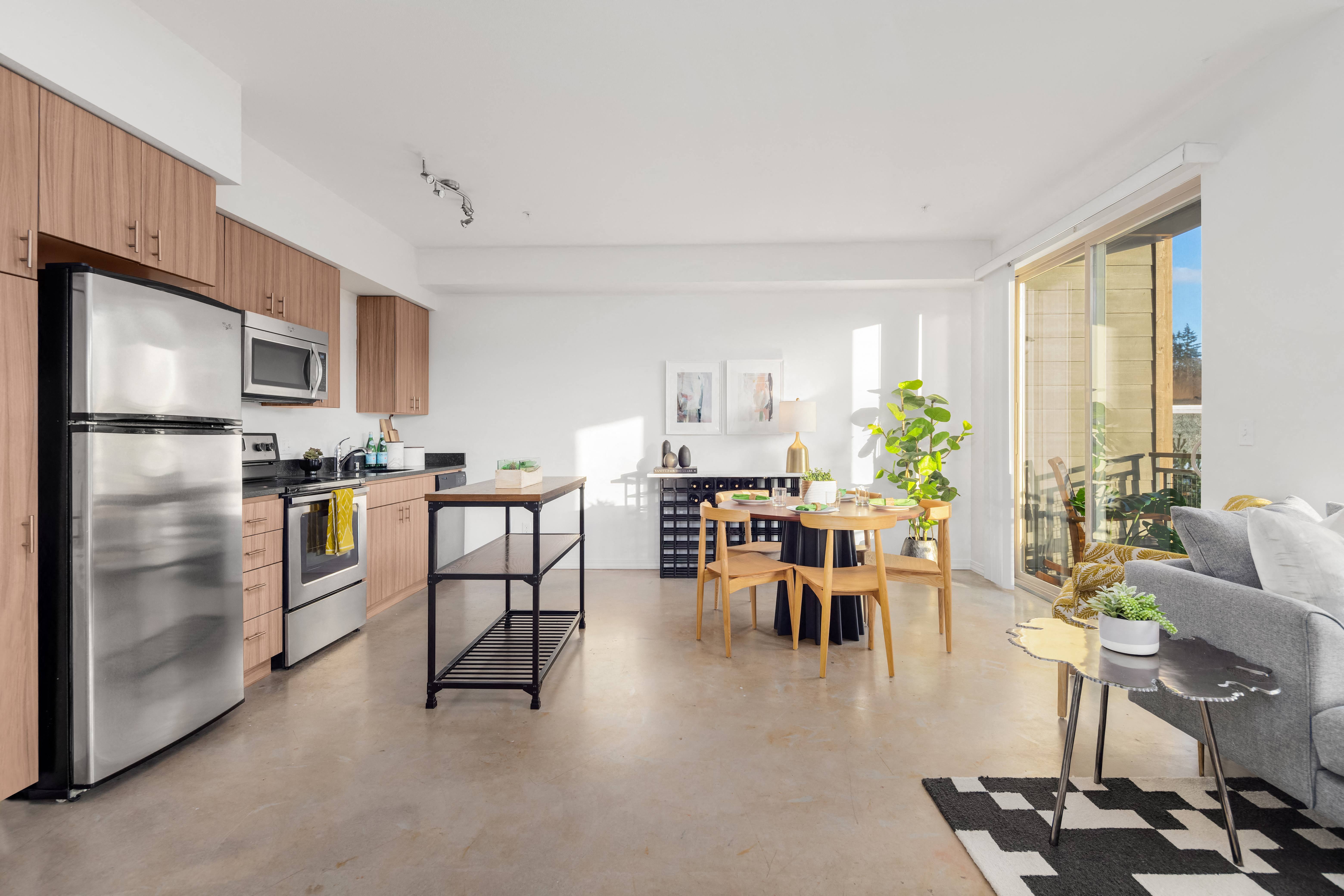 a living area with a kitchen and a dining room with a table and chairs