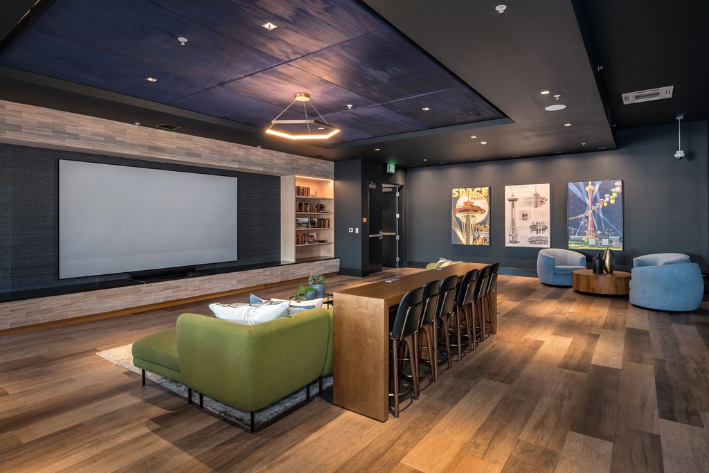 a room with a projector screen and a table with chairs