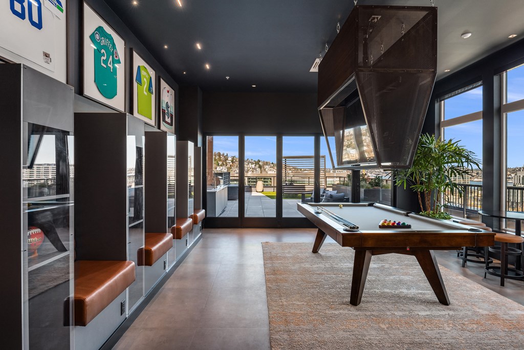 a games room with a pool table and views of the city
