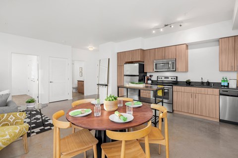 a living room and kitchen with a table and chairs