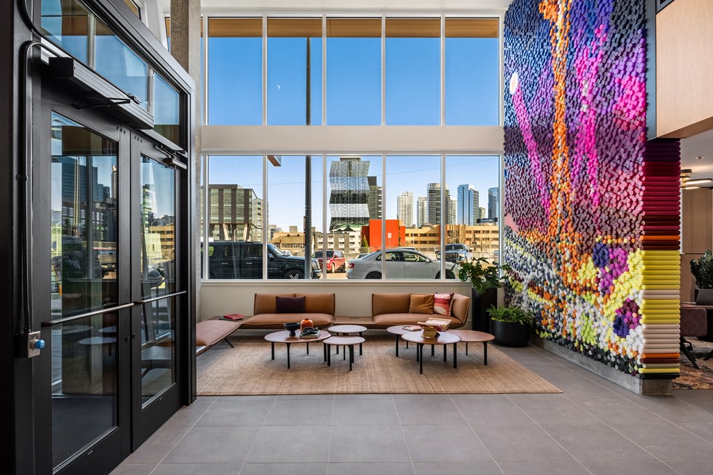 a patio with a couch and tables in front of a window