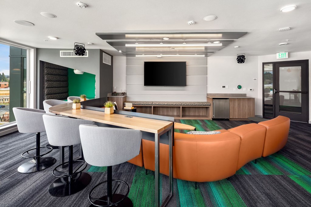 a conference room with a table and chairs and a television