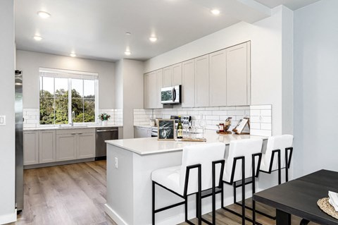 an open kitchen with a large island with white counter tops