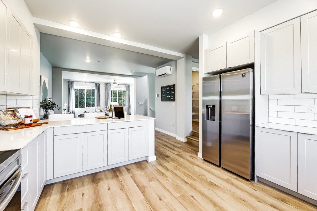 a kitchen with white cabinets and stainless steel appliances