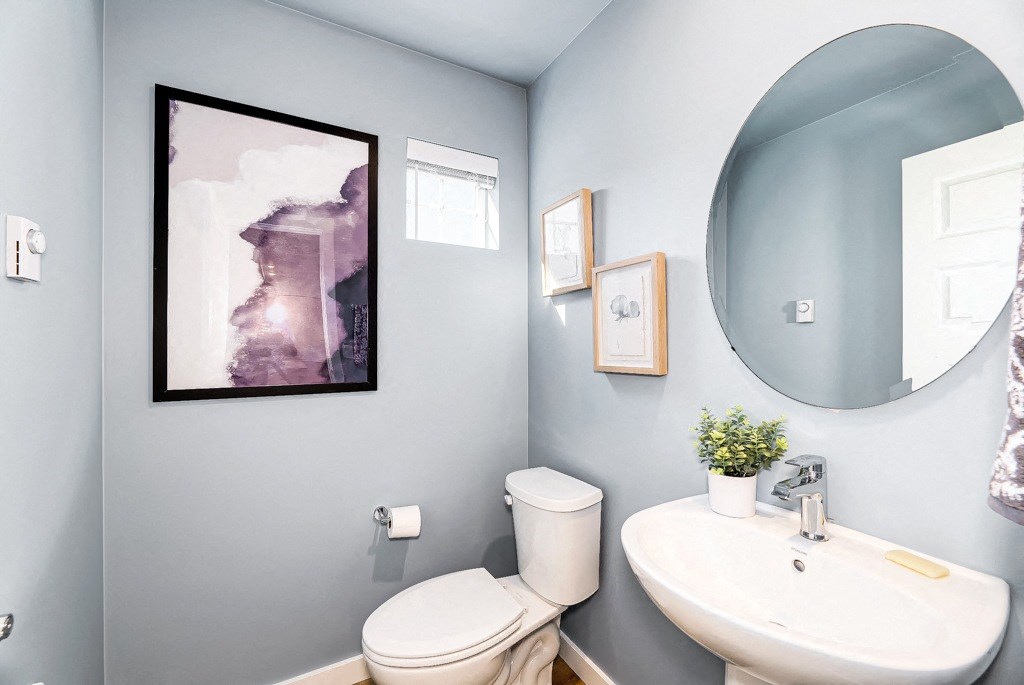 a bathroom with blue walls and a white sink and toilet