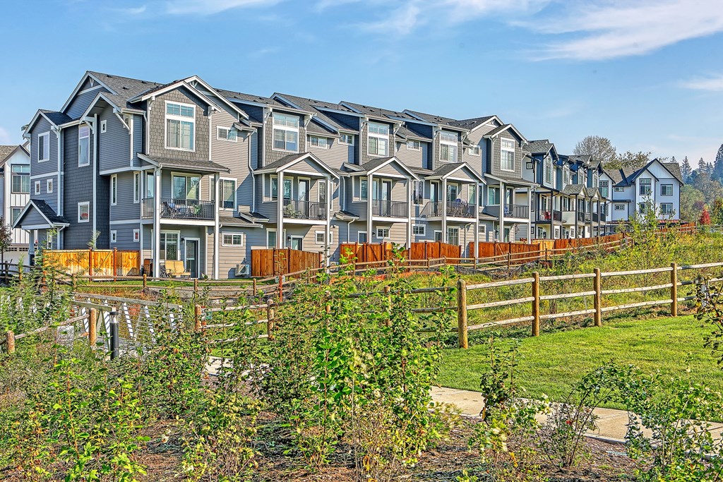 a row of houses on a hillside with a garden in front of them