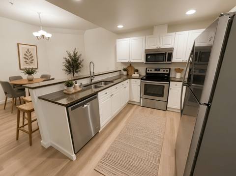 A modern kitchen with white cabinets and stainless steel appliances.