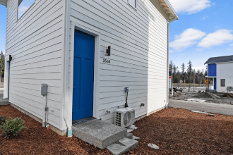 A white house with a blue door and a small porch.