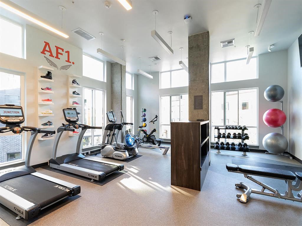 a gym with treadmills and other exercise equipment in a large room